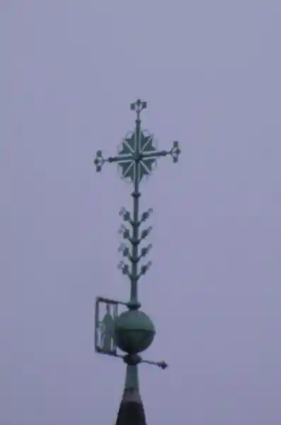 Cross with arrow-like points and a flower-like solar disc at its center